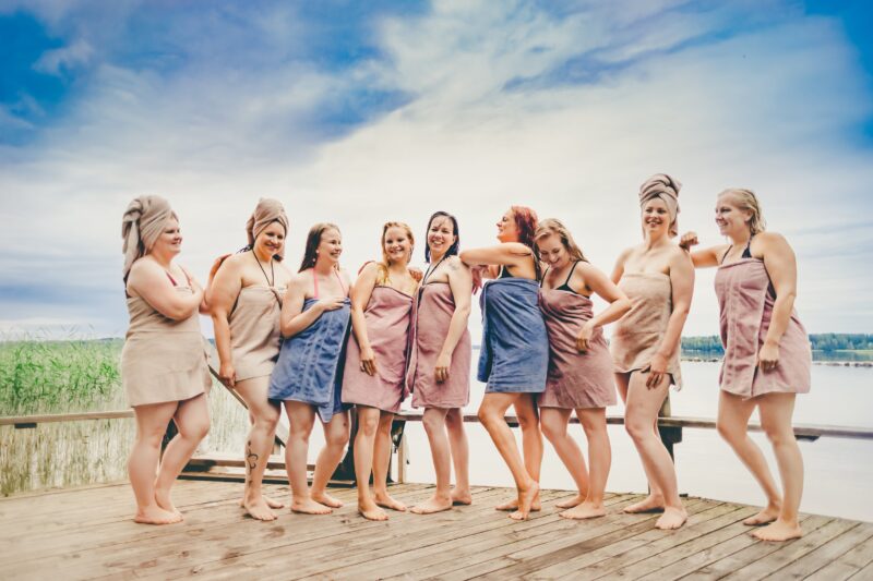 Naisia pyyhkeet ympärillä rannalla.