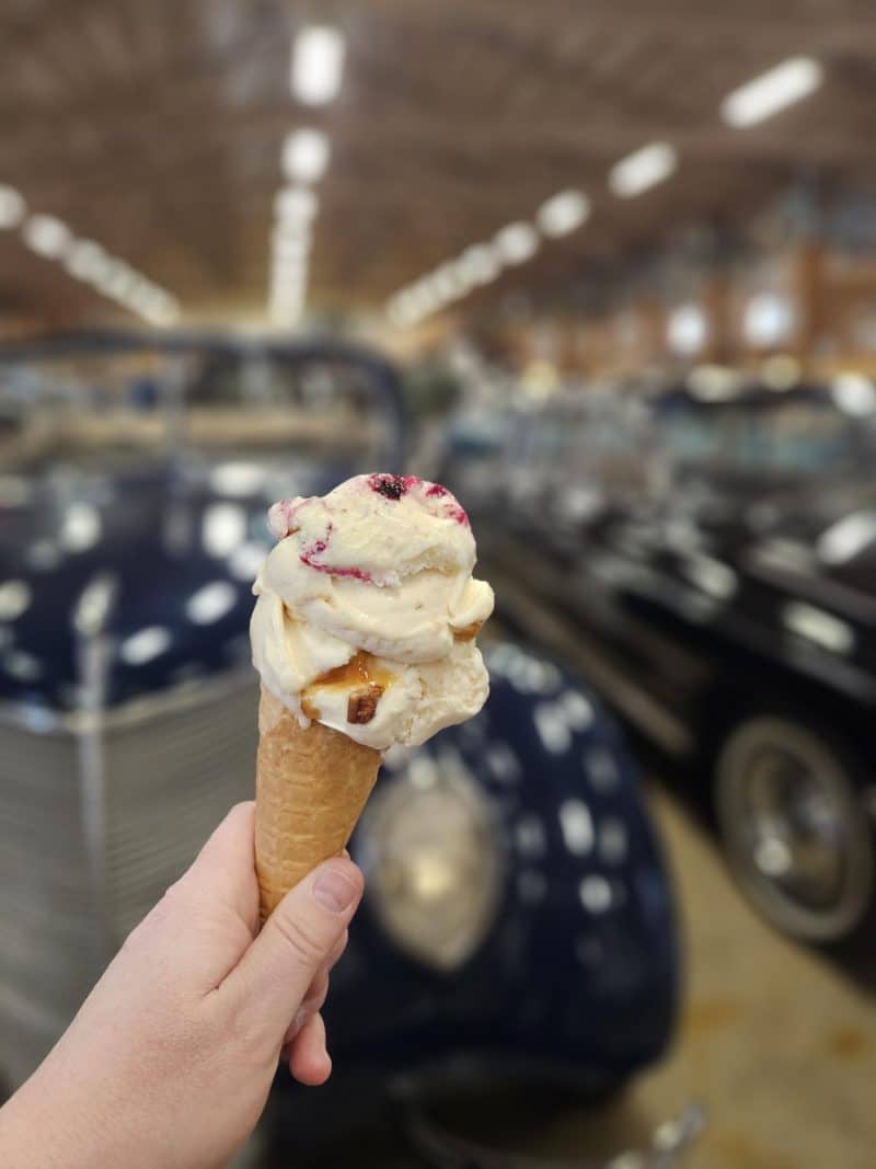 Kuvassa jäätelö ja taustalla vanhoja autoja Vehoniemen automuseossa Kangasalla